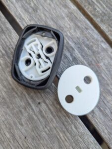 view of the inside of two plastic joystick interiors, one with holes in it and a worn out inner slot; the other freshly printed, solid, and robust