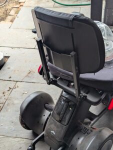 metal powerchair frame with seat back bolted to it, plain and utilitarian