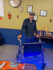 vince lopez in a flat cap holding a walker decorated with glowing lightstrips