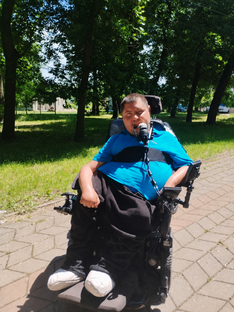 Man using a power wheelchair with chin control in a park