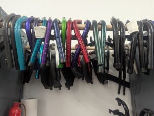 colorful footrests for manual wheelchairs, hung up in a row on a dowel