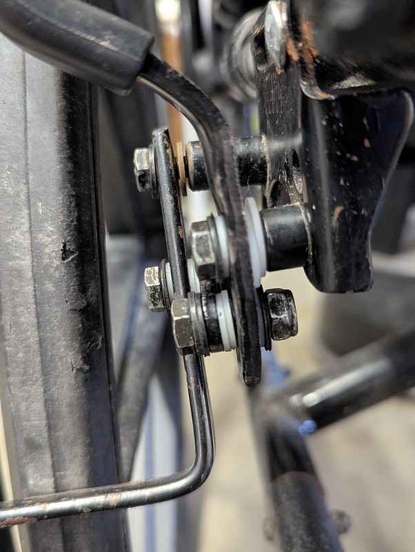 close up of dusty, greasy, worn looking wonky wheelchair brakes