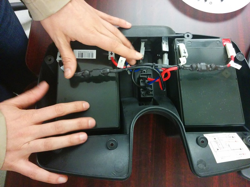 hands on a large, partially disassembled battery case
