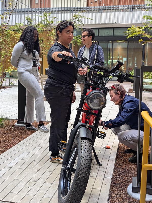 Dewi, olga, and angello tending to an ebike